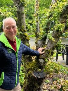 Photo of Tom Kuehne standing in front of a Japanese Maple at the Gig Harbor Campus entrance.
