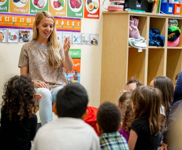 A woman teaches a classroom of toddlers